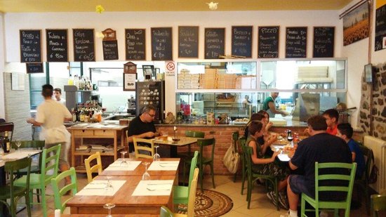 Sala interna di Pronto Pizza con tavoli, quadri alle pareti e atmosfera familiare